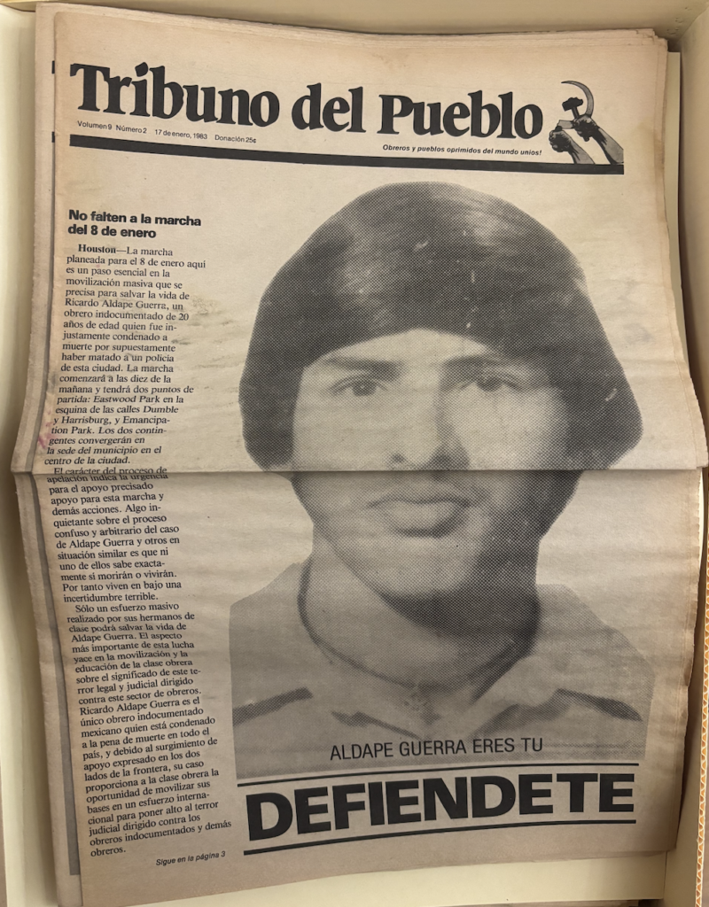 An old newspaper with a bold title reads “Tribuno del Pueblo” with a hammer and sickle next to it. On the left hand side, there is a thin column with the majority of the paper showing a man’s face in black and white. Below the image, in bold capital letters, reads “Defendiente”. 
